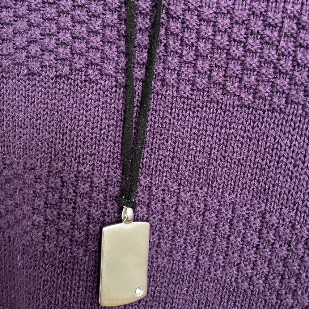 Cookie Lee silver tone pendant on black leather necklace.